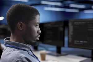 Engineer doing maintenance in data center facility to extend equipment life span and avoid downtime. Close up shot of IT expert monitoring servers for issues such as overheating or power fluctuations photo