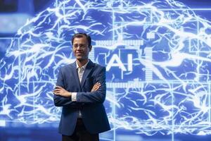 Jolly engineer using artificial intelligence computing simulating human brain thought processes. Portrait of upbeat Indian employee working with AI machine learning algorithms photo