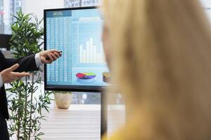 Financial advisor discussing with clients, recommending suitable financial products such as mutual funds. Agent teaching parent and daughter how to invest, offering statistical graphs photo