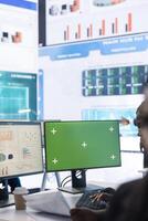 Enterprise worker examining annual sales statistics next to green screen, learning what to improve for business international development. Analyst reviewing key performance indicators. photo