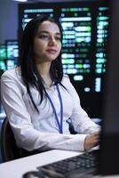Engineer monitoring and optimizing data center performance and capacity using computer. IT expert troubleshooting rackmounts to ensure optimal performance and minimize downtime photo