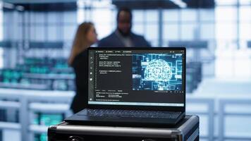 Focus on notebook used by engineers in server hub in blurry background using artificial intelligence computerized model. Close up of laptop with AI deep learning using pattern recognition, camera A photo