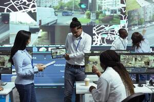 Indian manager presenting a new satellite navigation to locate truck drivers in traffic, using radar system and gps tracking. Control center operators receive instruction for shipment logistics. photo
