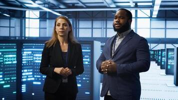 African american expert and coworker looking at holograms in data center, working together. Team members interacting with augmented reality AI visualization in server hub, camera A photo