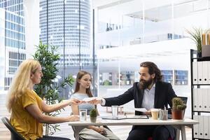 Financial adviser providing clients with informative leaflets on retirement planning, tax issues and wealth management. Agent in office assisting clients in setting up investment accounts photo