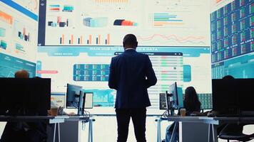 Administrative assistant examining important big data visualizations on a huge display, creating an analysis to review key performance indicators and business efficiency. Camera B. photo
