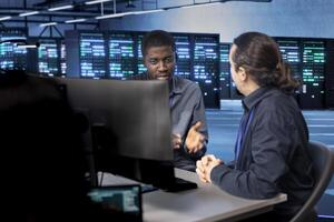 System administrators reconfiguring server room to optimize it for data processing requirements of customers. IT experts ensuring data center equipment operates efficiently, doing maintenance photo