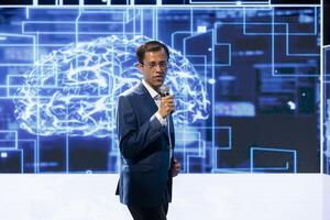 Engaging presenter talking at AI convention using microphone, sharing industry expertise to inspire audience. Professional exploring latest artificial intelligence technologies and tools at tech event photo