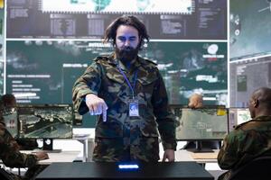 Military personnel examining global satellite CCTV footage on a hologram, monitoring infantry unit soldiers deployed in the field. Trained recruit employing holographic projection. photo