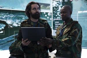 Army IT engineering team collects tactical data with surveillance radar system, creating operational maps to aid troopers during the defense mission. Gather intelligence for safety. photo