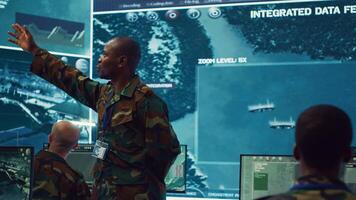 Major general updating and maintain the command center databases with current operational data, monitoring surveillance radar footage to ensure national safety. Control room. Camera A. photo