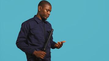 Portrait of security agent patrolling to secure assigned post, wearing bodycam, studio background. Guardian using security surveillance body camera while handling security breaches, camera B photo