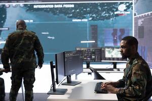 Military crew in a high tech operations command post managing information collected from radar cctv systems, real time data to support defense missions. Army protocols for national security. photo