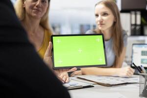 Financial adviser assisting clients in setting up investment accounts with green screen tablet, conducting audit. Consultant uses financial planning software on mockup device to help family, close up photo