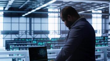 Software developer in data center using artificial intelligence computing simulating human brain. IT support staff member working on notebook with AI machine learning algorithms, camera A photo