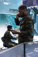 Military expert in high tech command post communicate satellite data, monitoring surveillance systems and real time data on a world map to support national security operations and strategic planning. photo