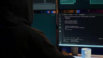 Dangerous man hacking, stealing credit card numbers and infiltrating banking systems, handheld camera shot. Close up of hacker running code in apartment on PC monitors, camera A photo