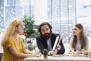 Financial advisor creating reports on investment performance and activity on tablet, showing them to clients. Agent using device to develop portfolio for customers, maximizing financial gains photo