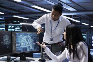 Team of data researchers using AI tech to do checkup in server room providing storage. Teamworking colleagues in data center using PC to enable artificial intelligence to process datasets for training photo