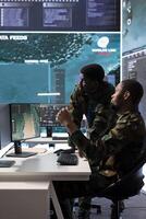 Team of army experts in a command post power base monitors satellite footage, collecting real time data and transmitting important details for a n operational success. Help with decision making. photo