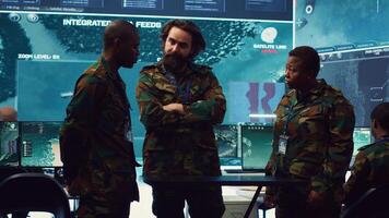 Diverse army officers examining real time data on a hologram, working with high tech holograph in a military command center for surveillance. Gather intelligence to support field troops. Camera A. photo