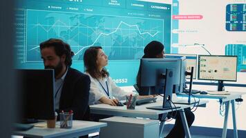 Team of diverse business consultants study feedback on old projects to improve their work for the future, developing new strategies in coworking space monitoring room. Startup activity. Camera A. photo