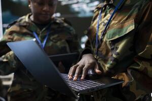 Military troopers communicating gps coordinates used in tracking hostile vessels to national guard, collecting real time data from reconnaissance CCTV system. Army staff in control room base. photo