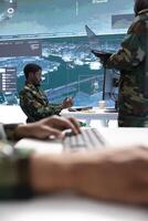 Army intelligence specialists use advanced computer systems and satellite data to enhance national security. Provide critical information and strategic planning in a high tech military control room. photo