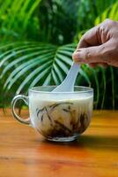 A man's hand stirring ice dawet photo