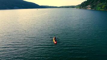 two in a canoe on a large lake. Resting by the lake and canoeing in the evening. video