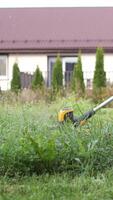 vertical Gardener actively trimming grass with a string trimmer video