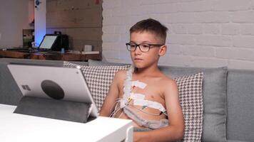 boy with glasses undergoes heart examination and watches videos