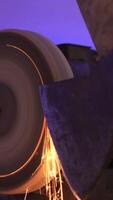 vertical close up of sharpening an axe on a machine with a grinding stone video