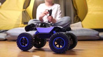 boy plays with a radio-controlled car, controls the remote control of a toy car video