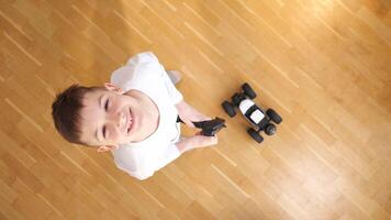 top view boy standing on the floor, controls toy rc car with a remote control video