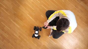 top view of a man playing with a model of a radio-controlled car video
