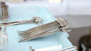 Close-up of surgical instruments in use during an operation, set against the backdrop of a busy operating room. This photo highlights the precision and essential tools involved in a medical procedure video