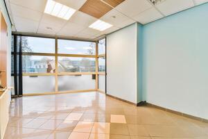 An empty office with a large window and tile floor photo