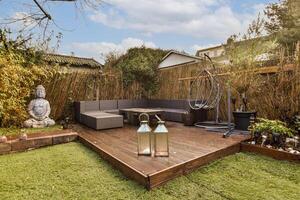 A wooden deck with a couch and a lantern photo