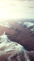 large snow patch left over on the volcanic rock field of a mountain in summer video