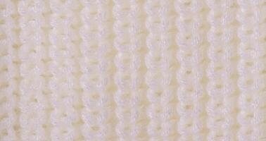 Knitted light background web size. Part of knitted clothes macro photo. photo