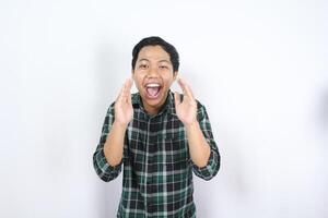 handsome attractive asian young man standing over isolated background screaming with excited expression announcing discount and sales photo