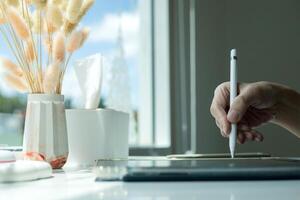 Hand using digital stylus writing on tablet. Concept of digital signature Signing documents electronically via tablet or taking notes electronic photo