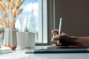 Hand using digital stylus writing on tablet. Concept of digital signature Signing documents electronically via tablet or taking notes electronic photo