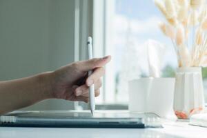 Hand using digital stylus writing on tablet. Concept of digital signature Signing documents electronically via tablet or taking notes electronic photo