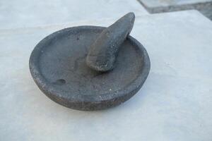 Stone Mortar and Pestle on a Grey Surface. photo