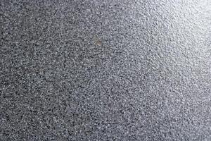 Close-up of rough textured gray surface with white specks. photo