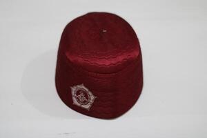 Maroon fabric cap with a white emblem. photo