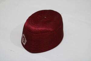 Maroon cap with white stitching and design. photo