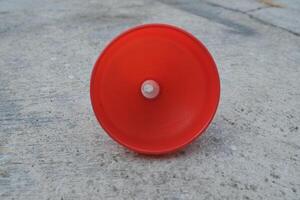 Red plastic funnel on a concrete surface. photo